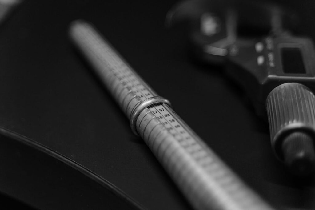 mascaro-creations.com Image Bijoux Site #12 Black and white image showing a focus on jewelry measuring tools on a workbench.